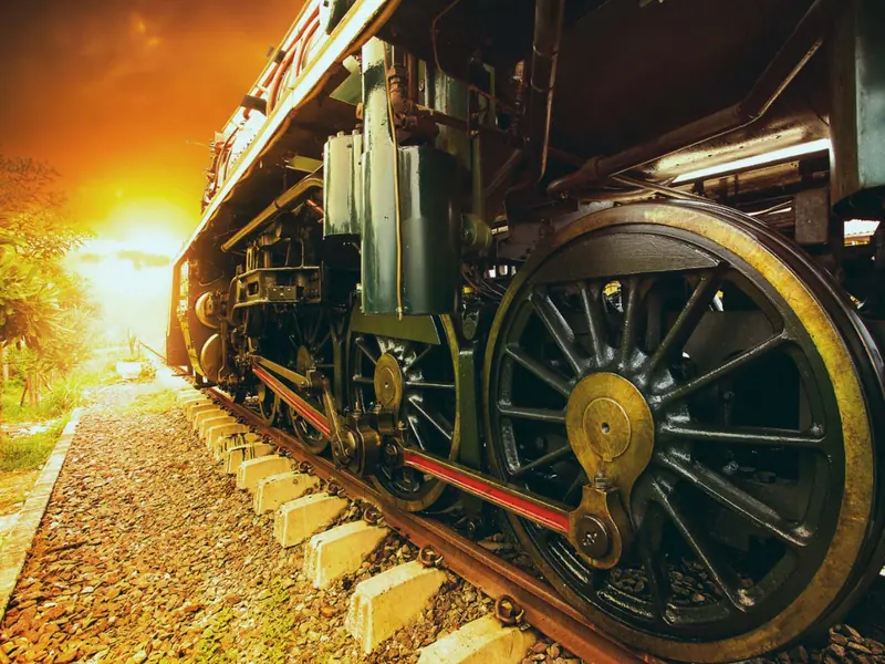 Train on track with bright yellow light at the background